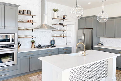 Transitional l-shaped cement tile floor and brown floor kitchen photo in Atlanta with white backsplash, marble backsplash and an island