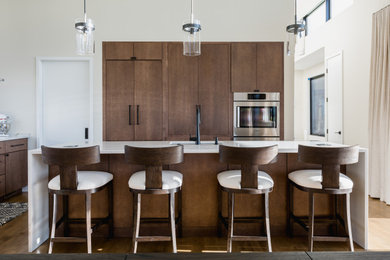 Inspiration for a large mid-century modern l-shaped light wood floor and brown floor kitchen remodel in DC Metro with an undermount sink, flat-panel cabinets, brown cabinets, quartz countertops, white backsplash, stainless steel appliances, an island and white countertops
