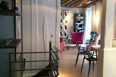 Cette image montre un salon design de taille moyenne et ouvert avec une salle de réception, un mur beige, parquet clair, aucun téléviseur et un sol marron.