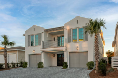 Large beach style white two-story concrete exterior home photo in Other with a metal roof and a gray roof