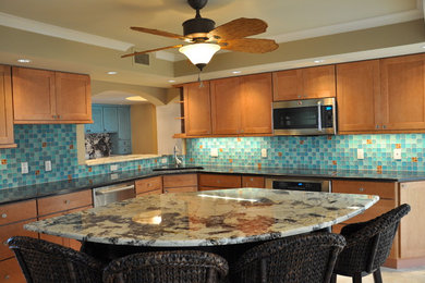 Inspiration for a large contemporary travertine floor eat-in kitchen remodel in Miami with an undermount sink, granite countertops, blue backsplash, glass tile backsplash, stainless steel appliances, an island, louvered cabinets and distressed cabinets
