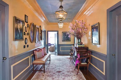 Example of a mid-sized classic medium tone wood floor entryway design in New York with yellow walls and a blue front door