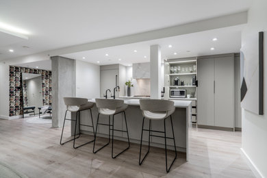Inspiration for a large contemporary galley vinyl floor and beige floor kitchen pantry remodel in Vancouver with a single-bowl sink, flat-panel cabinets, beige cabinets, quartz countertops, white backsplash, quartz backsplash, paneled appliances, an island and white countertops