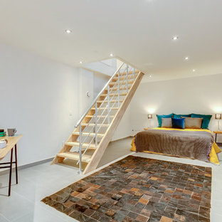 This is an example of a large scandinavian basement in Other with white walls, no fireplace and grey floors.