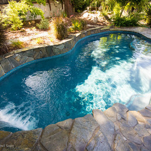 Idéer för en mellanstor modern pool på baksidan av huset, med en fontän och stämplad betong