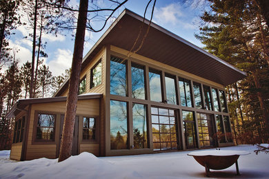 Large rustic brown two-story vinyl exterior home idea in Other with a metal roof