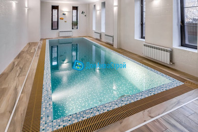 This is an example of a medium sized mediterranean rectangular infinity swimming pool in Other with tiled flooring.