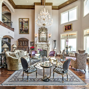 Diseño de salón para visitas abierto, mediterráneo, extra grande, sin televisor, con paredes púrpuras, suelo de madera oscura, chimenea tradicional, marco de chimenea de piedra y suelo marrón