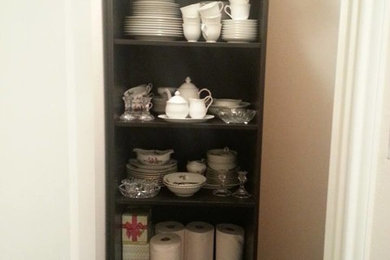 Inspiration for a small timeless closet remodel in Austin with open cabinets and dark wood cabinets
