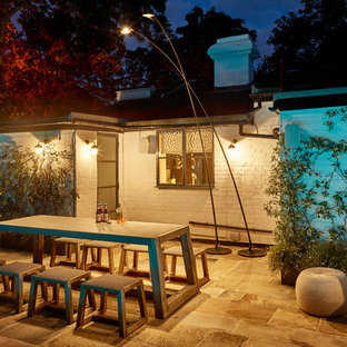 Stilmix Garten hinter dem Haus mit Sportplatz, Feuerstelle und Natursteinplatten in London