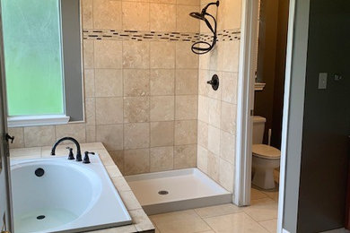 Mid-sized elegant master beige tile and travertine tile ceramic tile and beige floor bathroom photo in Houston with raised-panel cabinets, gray walls, solid surface countertops, a hinged shower door and white countertops