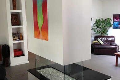 Example of a mid-sized trendy open concept slate floor living room design in New York with white walls and a two-sided fireplace