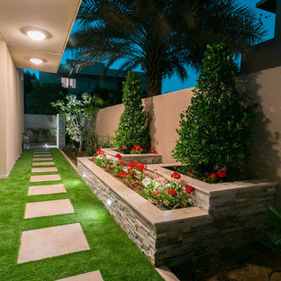 Design ideas for a small contemporary side yard formal garden in Other with concrete pavers and with raised garden bed.