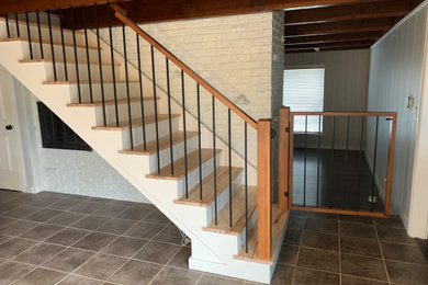Diseño de escalera recta moderna de tamaño medio con escalones de madera, contrahuellas de madera y barandilla de varios materiales