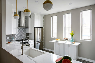 Inspiration for a mid-sized transitional l-shaped kitchen remodel in Chicago with an undermount sink, white cabinets, quartz countertops, multicolored backsplash, ceramic backsplash, stainless steel appliances, a peninsula and shaker cabinets