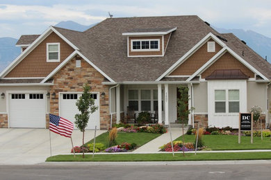Example of a mid-sized arts and crafts beige two-story mixed siding gable roof design in Other