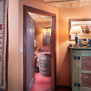 Idées déco pour une salle d'eau éclectique avec un lavabo intégré, un placard en trompe-l'oeil, des portes de placard en bois sombre, un plan de toilette en cuivre, un mur orange et béton au sol.