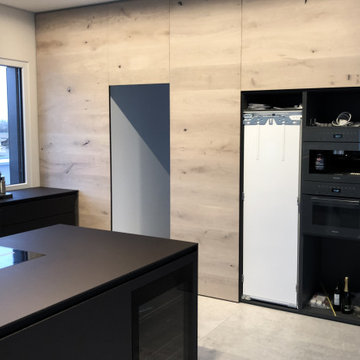 Küchentraum in Schwarz mit Holzwand und verstecktem Raum