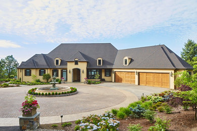 Inspiration for a large timeless yellow two-story stucco house exterior remodel in Portland