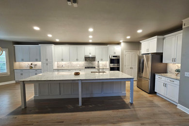 Inspiration for a mid-sized timeless l-shaped eat-in kitchen remodel in Nashville with shaker cabinets, white cabinets, granite countertops and an island