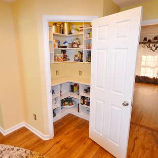 На фото: большая угловая кухня в классическом стиле с врезной раковиной, фасадами с выступающей филенкой, фасадами цвета дерева среднего тона, столешницей из кварцевого композита, техникой из нержавеющей стали, полом из линолеума, островом, бежевым полом и кладовкой с