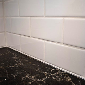 White Kitchen with Brown Quartz Countertop and Brick Flooring and Entryway