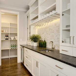 Craftsman kitchen pantry appliance - Example of an arts and crafts medium tone wood floor kitchen pantry design in Seattle with an undermount sink, recessed-panel cabinets, white cabinets, granite countertops, multicolored backsplash, porcelain backsplash, stainless steel appliances and an island