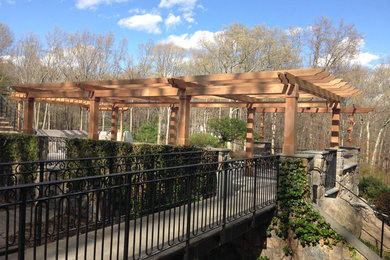 Inspiration for a mid-sized traditional backyard patio in New York with natural stone pavers and a pergola.