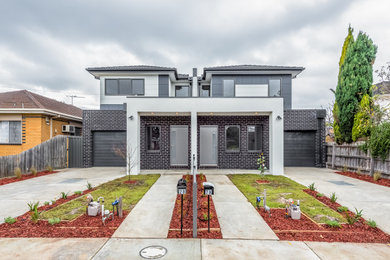 Design ideas for a contemporary two-storey brick grey duplex exterior in Melbourne with a hip roof and a grey roof.