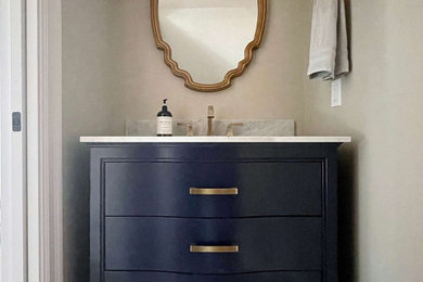Inspiration for a small cottage powder room remodel in Los Angeles with blue cabinets, marble countertops, white countertops and a freestanding vanity