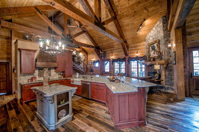 This is an example of a large country u-shaped open plan kitchen in Other with a farmhouse sink, flat-panel cabinets, granite benchtops, stainless steel appliances, dark hardwood floors and multiple islands.