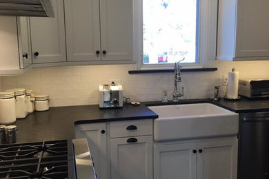 Kitchen - traditional ceramic tile kitchen idea in Chicago with a farmhouse sink, recessed-panel cabinets, white cabinets, granite countertops, white backsplash, ceramic backsplash, stainless steel appliances and an island