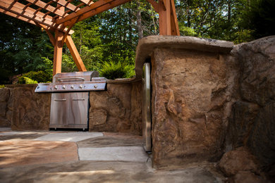 Inspiration for a large transitional backyard stone patio kitchen remodel in Philadelphia with a pergola