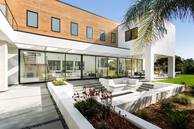 This is an example of a large contemporary two-storey white house exterior in Los Angeles with mixed siding and a flat roof.
