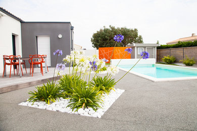 This is an example of a mid-sized modern backyard patio in Nantes with a container garden, gravel and no cover.
