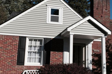 Inspiration for a large timeless red one-story mixed siding exterior home remodel in Detroit