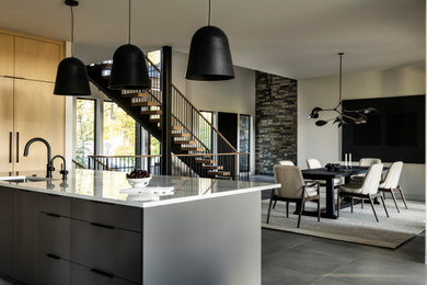 Huge trendy gray floor eat-in kitchen photo in Seattle with flat-panel cabinets, light wood cabinets, quartz countertops, white backsplash, cement tile backsplash, paneled appliances, an island and multicolored countertops