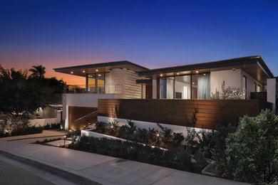 Large trendy beige split-level mixed siding exterior home photo in Los Angeles with a mixed material roof