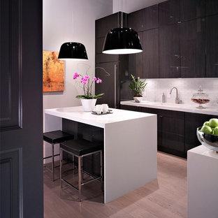 Mid-sized contemporary kitchen pantry designs - Kitchen pantry - mid-sized contemporary l-shaped light wood floor kitchen pantry idea in Las Vegas with an integrated sink, flat-panel cabinets, dark wood cabinets, white backsplash and an island