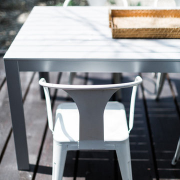 IKEA FALSTER Table with White Tolix Marais Chairs on Outdoor Deck with Woven Tra