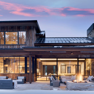 Country backyard patio in Denver with a fire feature, concrete pavers and a roof extension.