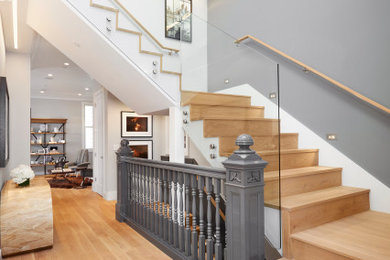 Imagen de escalera en U moderna grande con escalones de madera, contrahuellas de madera y barandilla de vidrio