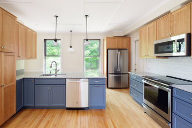 Example of a large classic light wood floor and coffered ceiling eat-in kitchen design in Portland Maine with a double-bowl sink, shaker cabinets, light wood cabinets, granite countertops, white backsplash, brick backsplash, stainless steel appliances and multicolored countertops