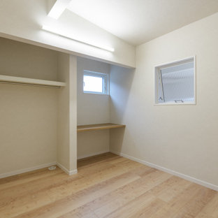 Esempio di una cameretta da letto moderna con pavimento in compensato e soffitto in carta da parati