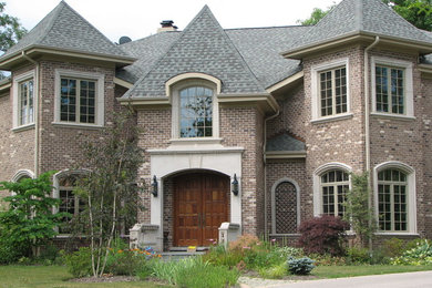 Large elegant two-story brick exterior home photo in Chicago with a hip roof