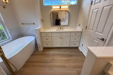 Example of a mid-sized trendy beige tile and ceramic tile laminate floor, beige floor and double-sink bathroom design in Other with shaker cabinets, white cabinets, a two-piece toilet, black walls, an undermount sink, quartz countertops, a hinged shower door, white countertops, a niche and a built-in vanity