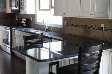 Example of a mid-sized classic l-shaped dark wood floor eat-in kitchen design in New York with a double-bowl sink, recessed-panel cabinets, white cabinets, granite countertops, beige backsplash, ceramic backsplash, stainless steel appliances and a peninsula