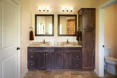 Design ideas for a mid-sized transitional master bathroom in Other with recessed-panel cabinets, dark wood cabinets, a two-piece toilet, beige walls, an undermount sink and granite benchtops.