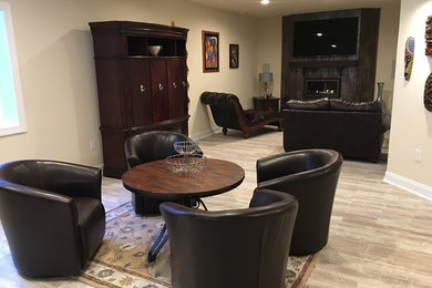 Inspiration for a large contemporary underground porcelain tile basement remodel in Philadelphia with beige walls, a standard fireplace and a tile fireplace