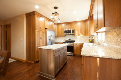Inspiration for a timeless u-shaped kitchen pantry remodel in Chicago with shaker cabinets, brown cabinets, stainless steel appliances and an island